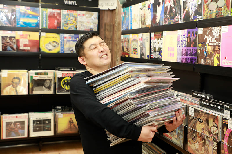 たくさんのレコードを抱える岩崎さん